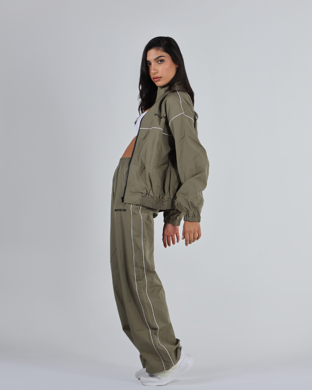 Woman wearing a green tracksuit on a white background