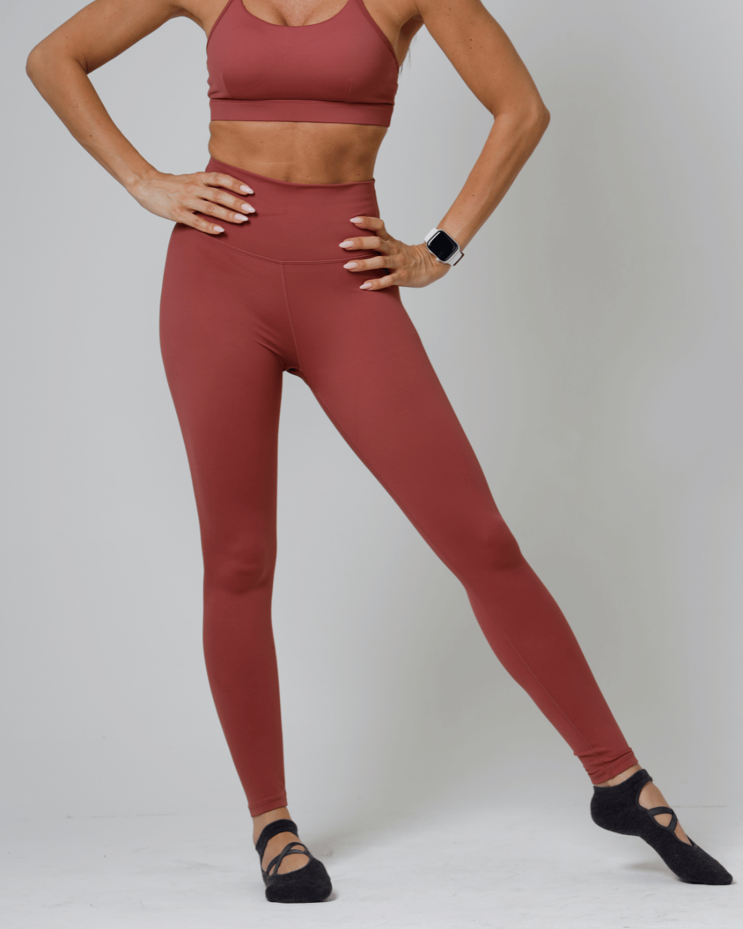 Women wearing a red athletic outfit on a plain background
