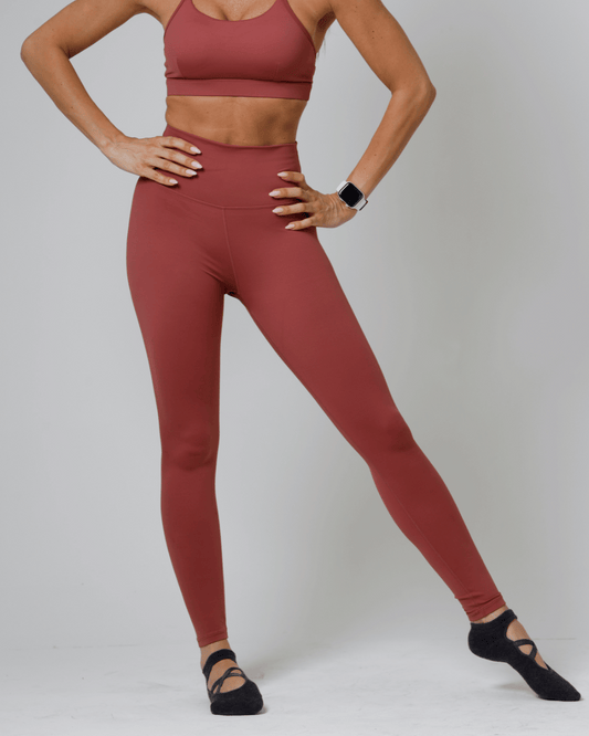 Women wearing a red athletic outfit on a plain background